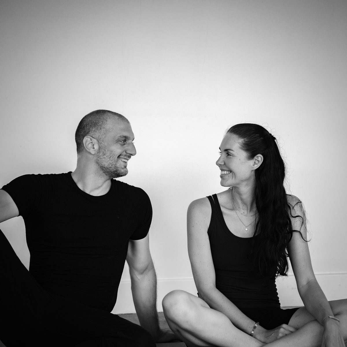 Markus and Holly sitting on the studio floor, laughing.