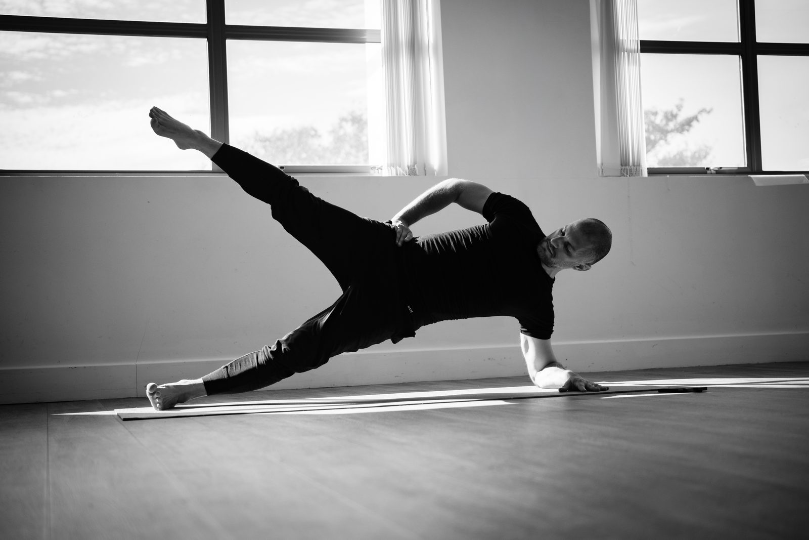 Markus in a supported side plank with the top leg lifted, pelvis held level.